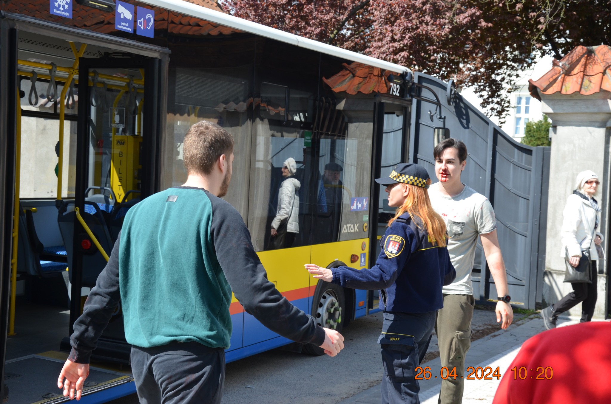 Strażniczka miejska kieruje uczestnikami pozorowanego wypadku przy autobusie podczas etapu rejonowego XXX Ogólnopolskich Mistrzostw Pierwszej Pomocy PCK w Płocku.
