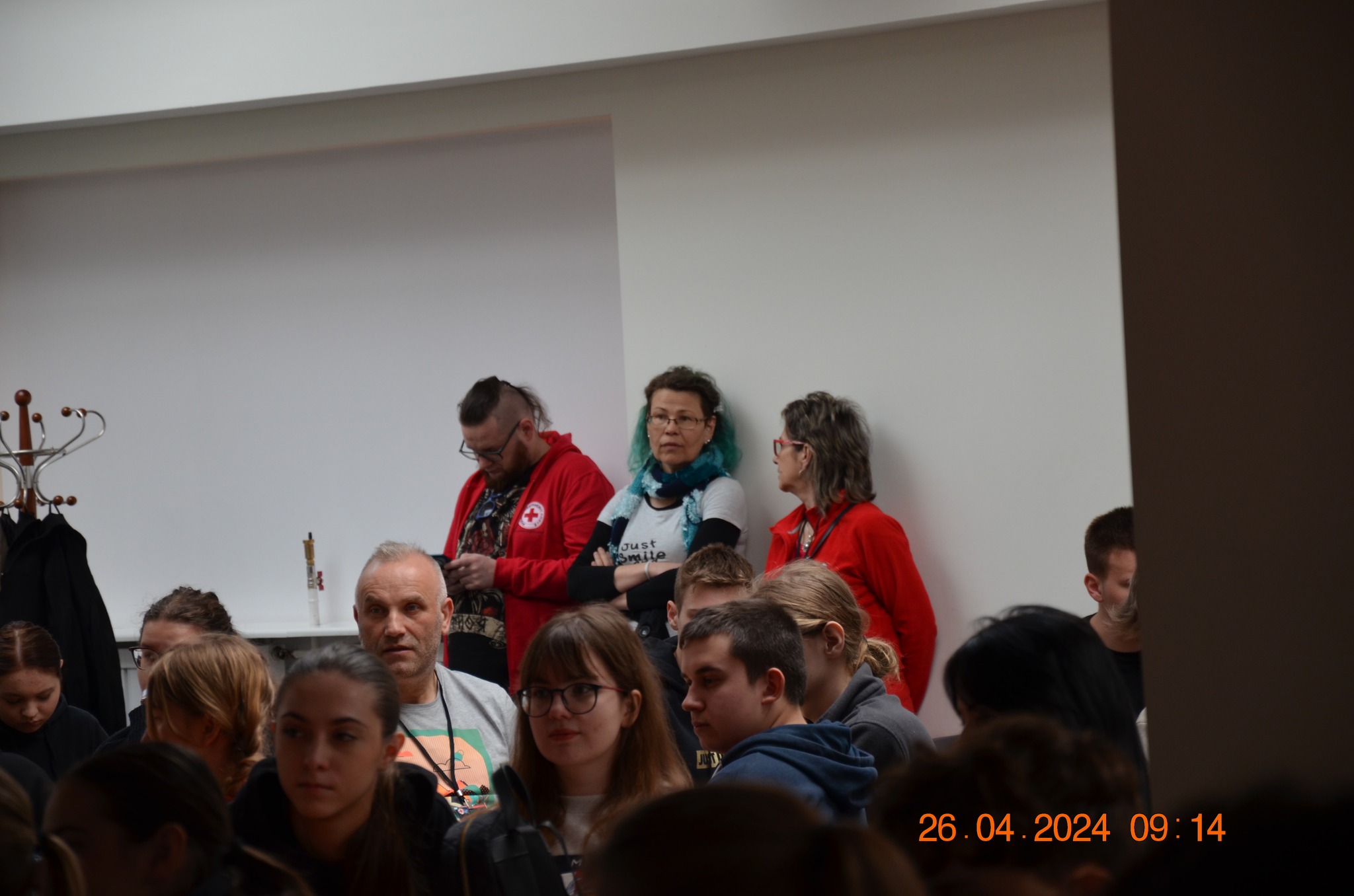 Uczestnicy i organizatorzy etapu rejonowego XXX Ogólnopolskich Mistrzostw Pierwszej Pomocy PCK w Płocku zgromadzeni w sali przed rozpoczęciem zawodów.