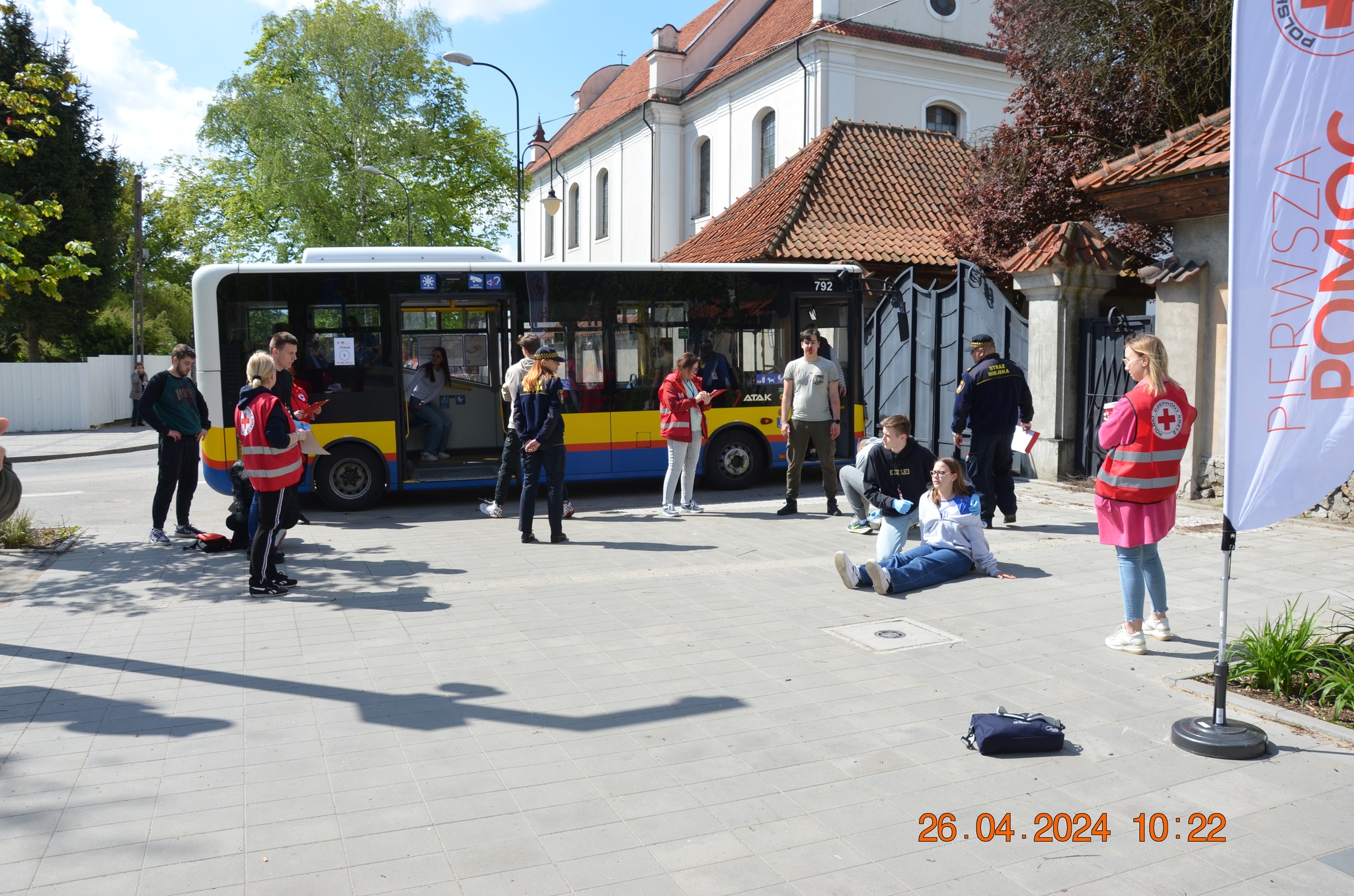 Uczestnicy etapu rejonowego XXX Ogólnopolskich Mistrzostw Pierwszej Pomocy PCK w Płocku ćwiczą udzielanie pomocy poszkodowanym w symulacji zdarzenia przy miejskim autobusie.