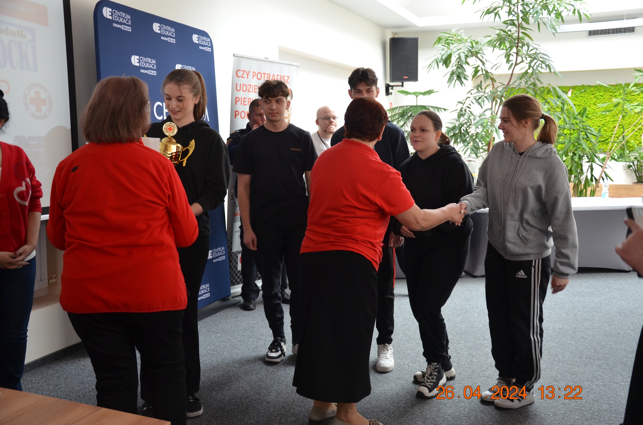 Młodzieżowa drużyna odbiera puchar i gratulacje od organizatorów podczas etapu rejonowego XXX Ogólnopolskich Mistrzostw Pierwszej Pomocy PCK w Płocku.