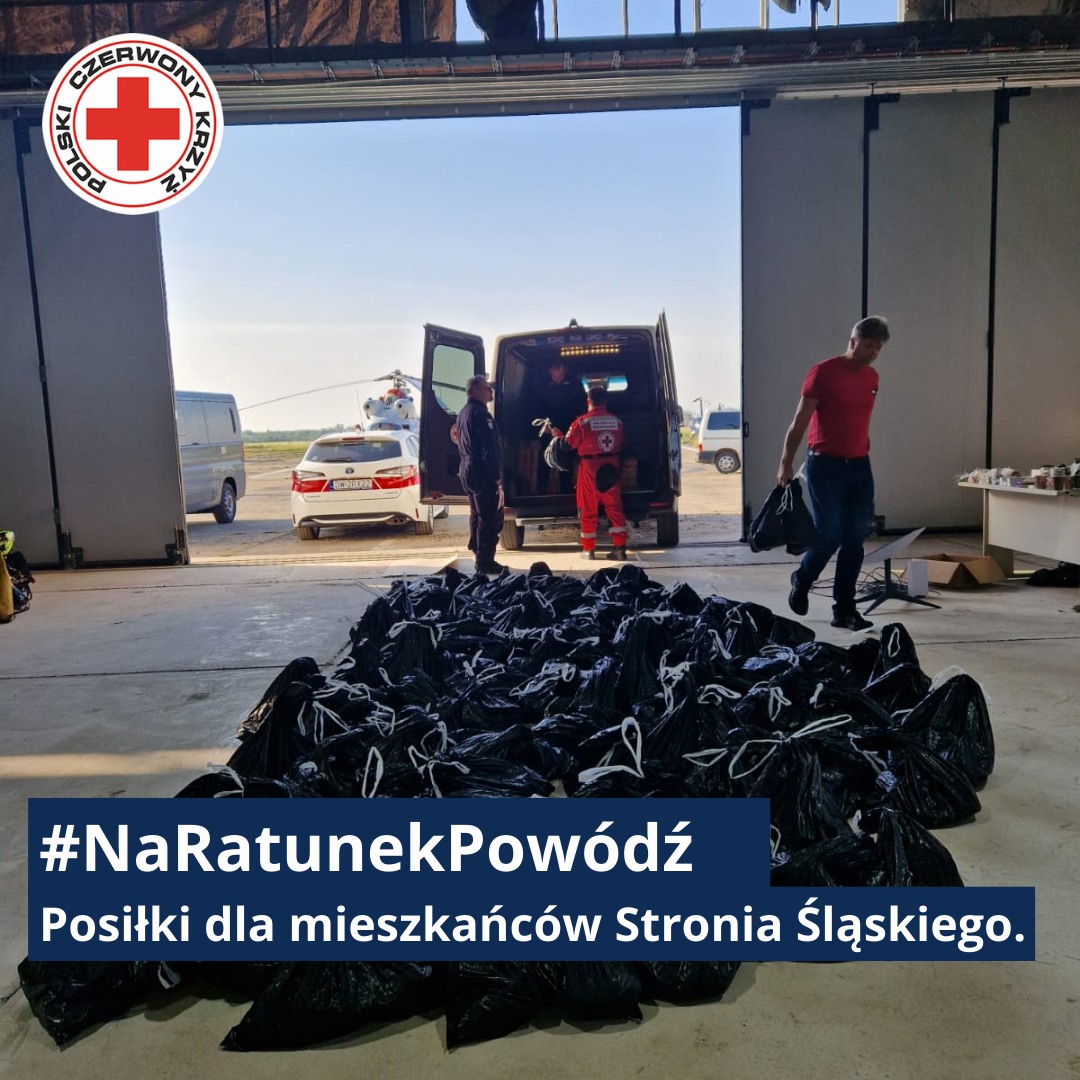 Wolontariusze Polskiego Czerwonego Krzyża przygotowują i załadowują setki paczek z pomocą żywnościową dla mieszkańców dotkniętego powodzią Stronia Śląskiego.