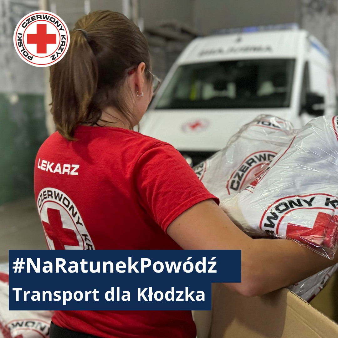 Lekarka Polskiego Czerwonego Krzyża ładuje do kartonu worki z pomocą humanitarną podczas organizowania transportu dla poszkodowanych powodzią w Kłodzku.