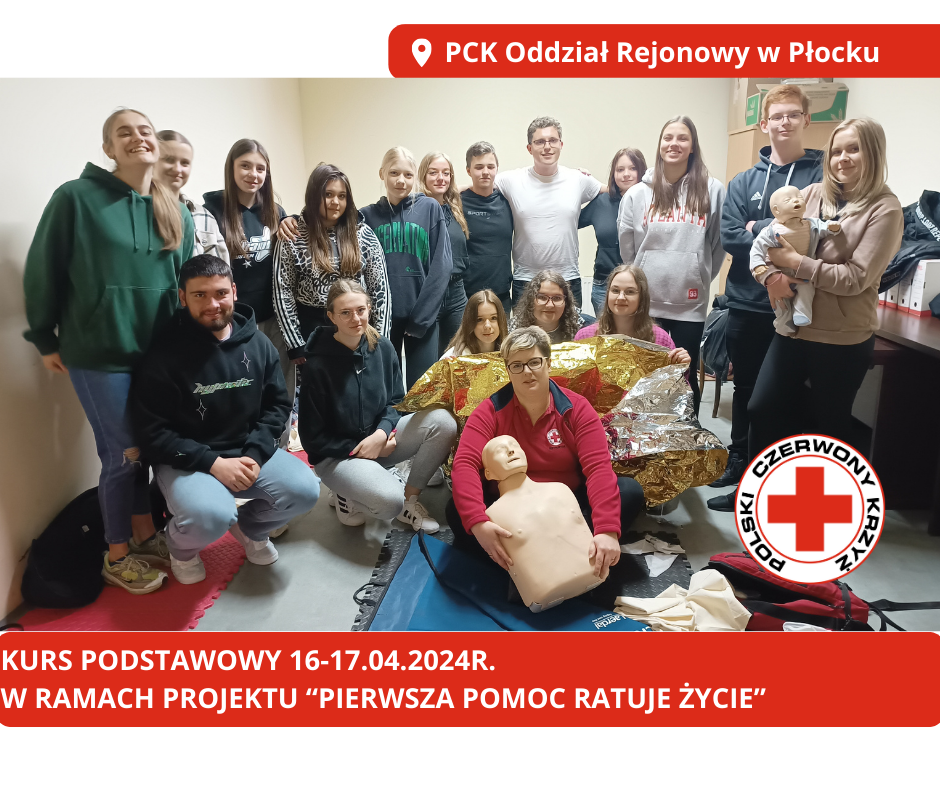 Grupa młodzieży i instruktorka PCK w sali szkoleniowej pozuje z fantomami i kocem termicznym po kursie pierwszej pomocy w Płocku.