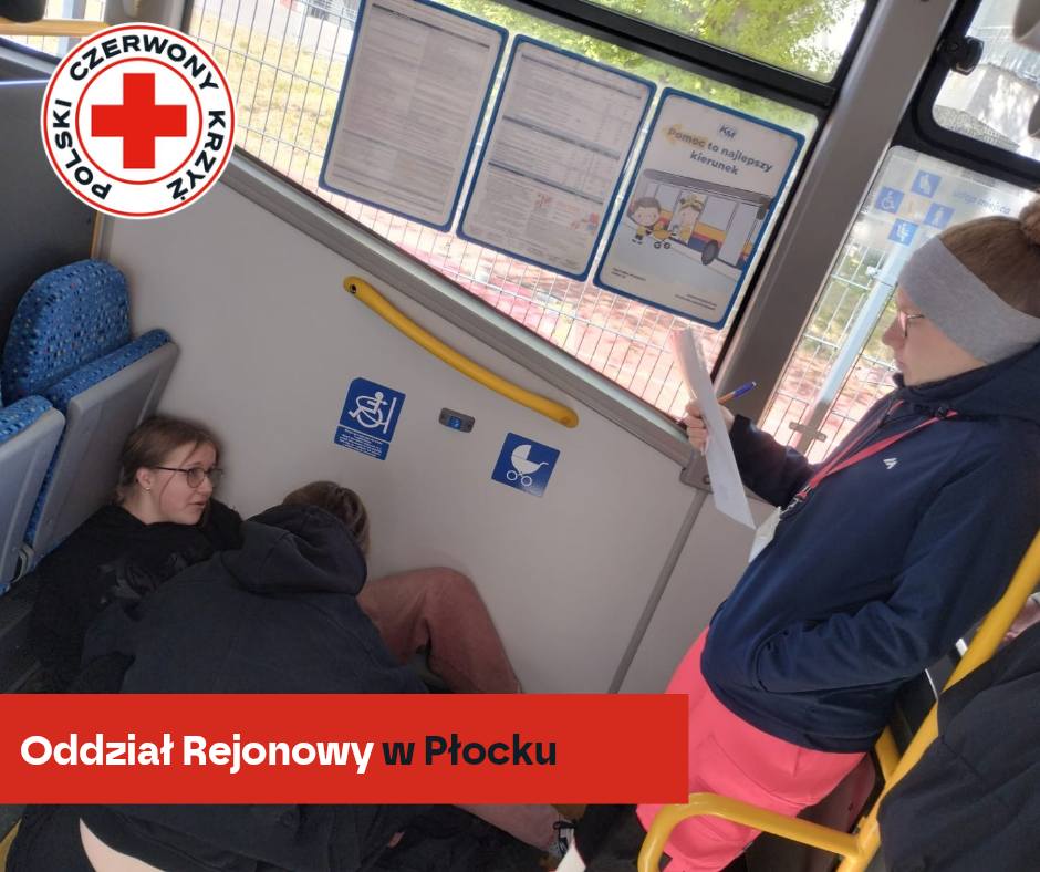 Uczestnicy XXXII Mistrzostw Pierwszej Pomocy PCK w Płocku przeprowadzają symulację udzielania pomocy poszkodowanemu w autobusie.