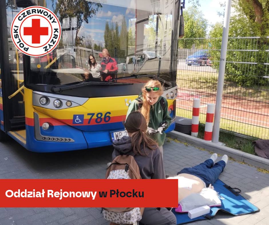 Uczestnicy XXXII Mistrzostw Pierwszej Pomocy PCK w Płocku ćwiczą udzielanie pomocy na fantomie osoby poszkodowanej przed miejskim autobusem.