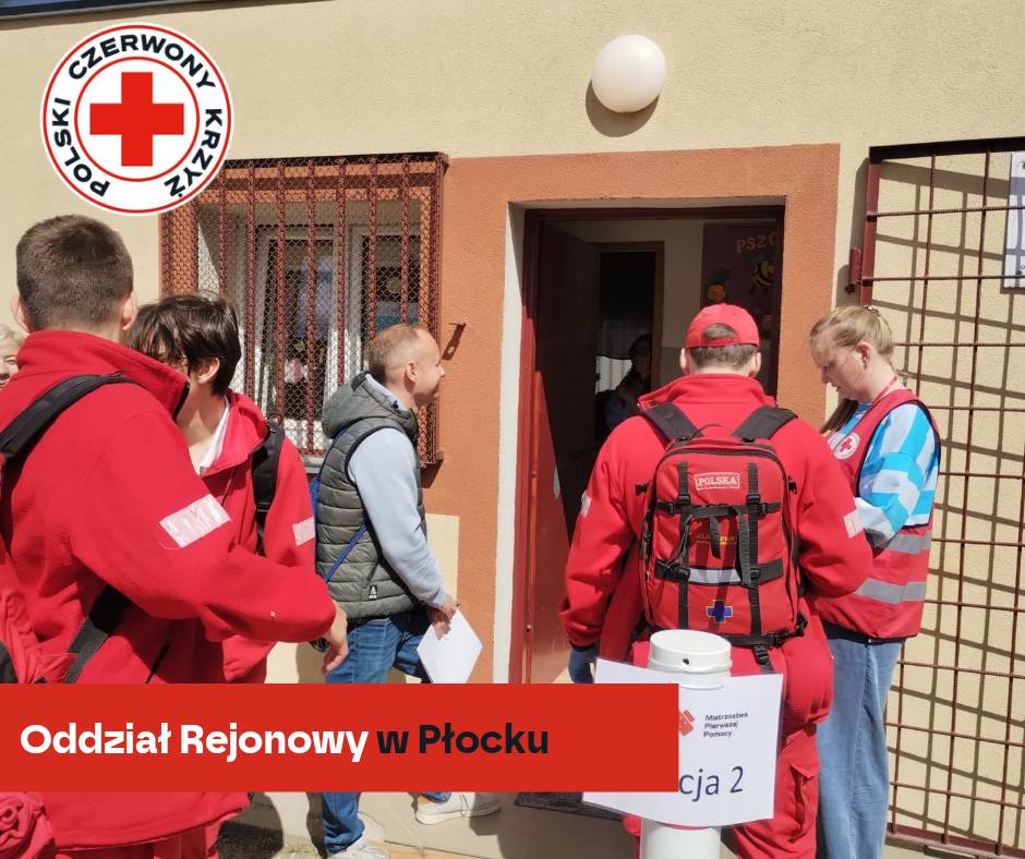 Grupa ratowników PCK w czerwonych strojach wchodzi do budynku podczas etapu rejonowego XXXII Mistrzostw Pierwszej Pomocy w Płocku.